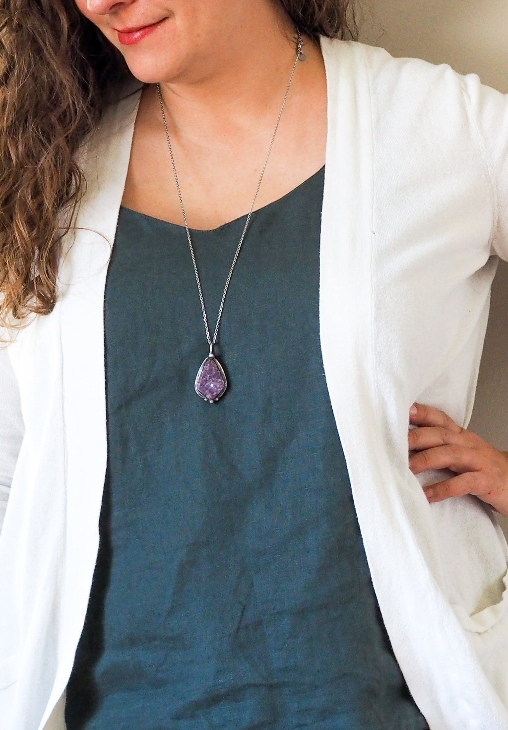 purple crystal talisman necklace on woman in blue top