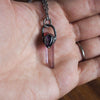 purple healing crystal talisman necklace in palm of hand