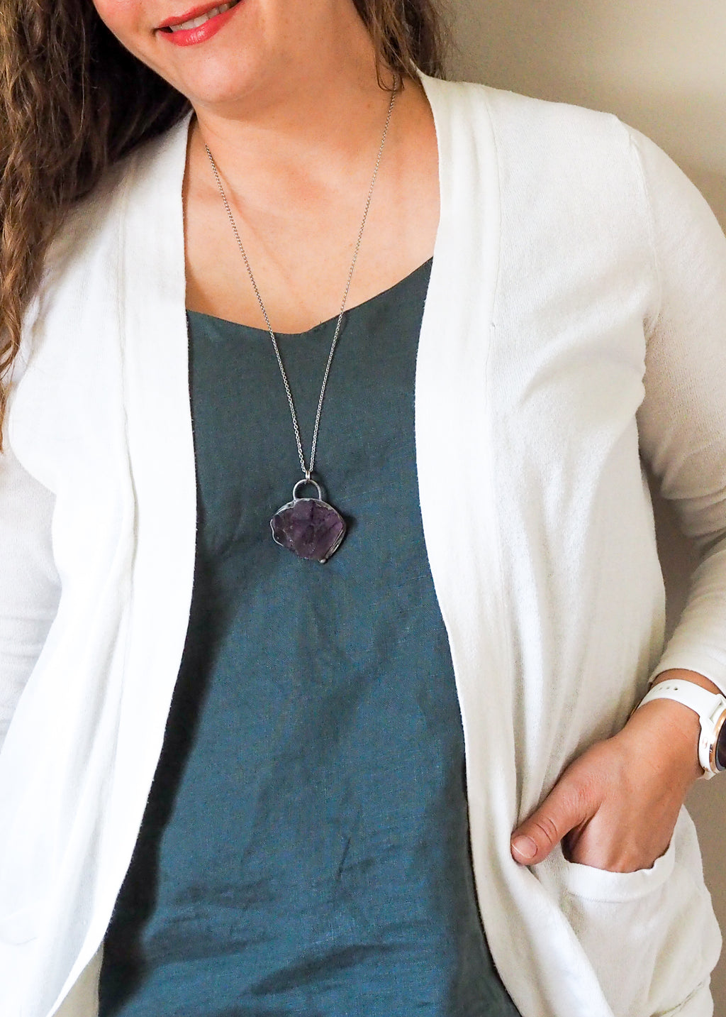 raw purple fluorite crystal talisman necklace woman in blue top