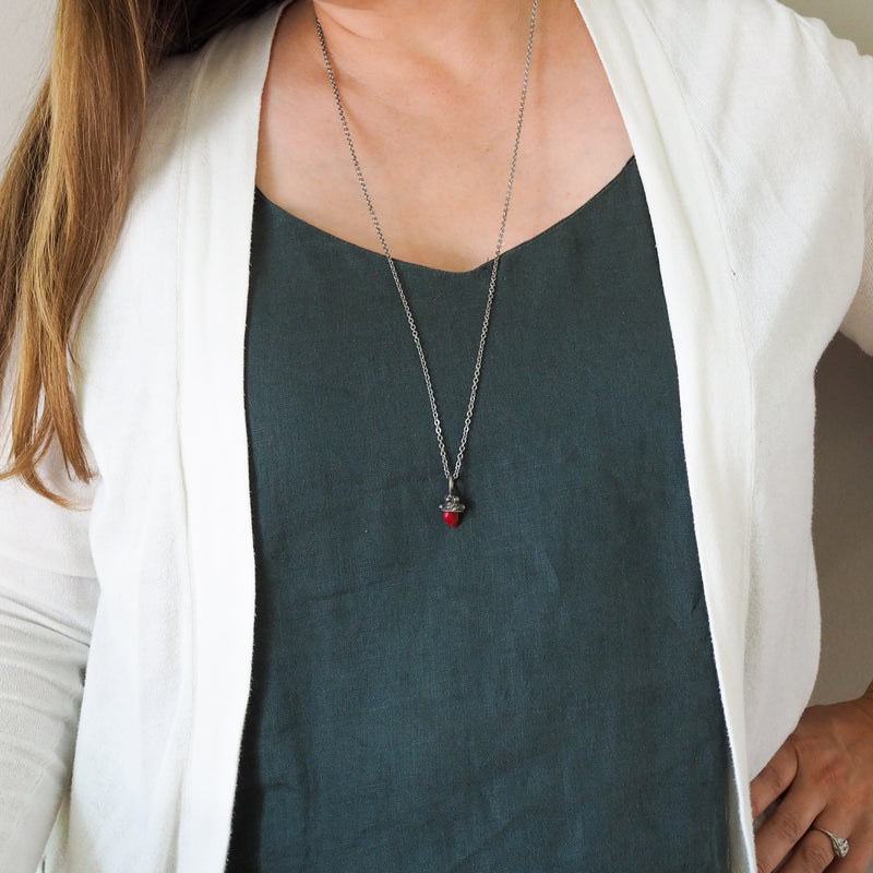red mushroom healing crystal talisman necklace on woman in blue top