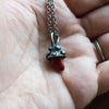 red mushroom healing crystal talisman necklace in palm of hand