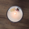 top view of lit sagittarius candle with yellow citrine crystal and botanicals
