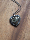 sparkly silver heart shaped healing crystal talisman statement necklace on wooden background