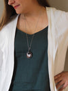 woman wearing blue top with red healing crystal talisman statement necklace