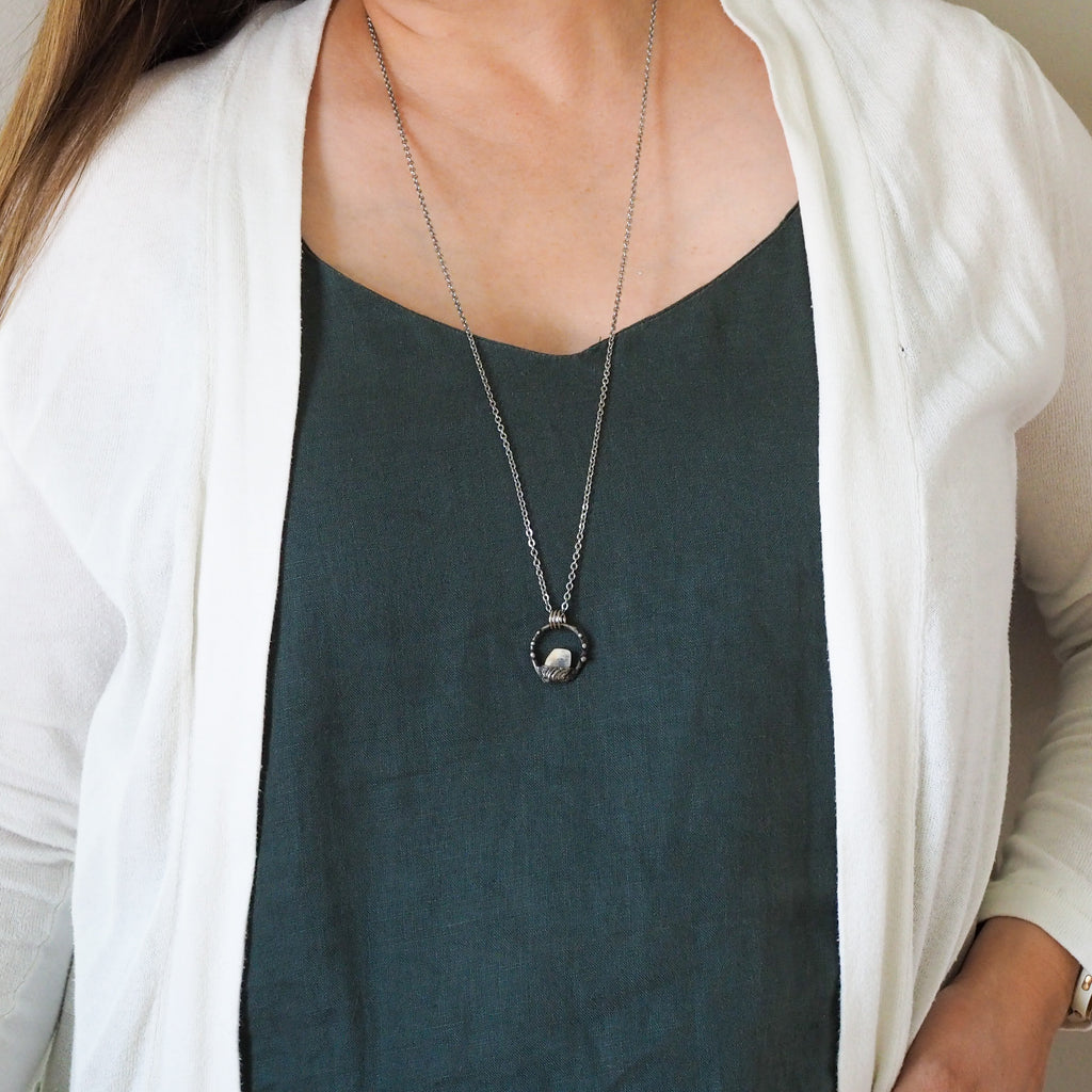 white moonstone healing crystal talisman necklace on woman in blue top
