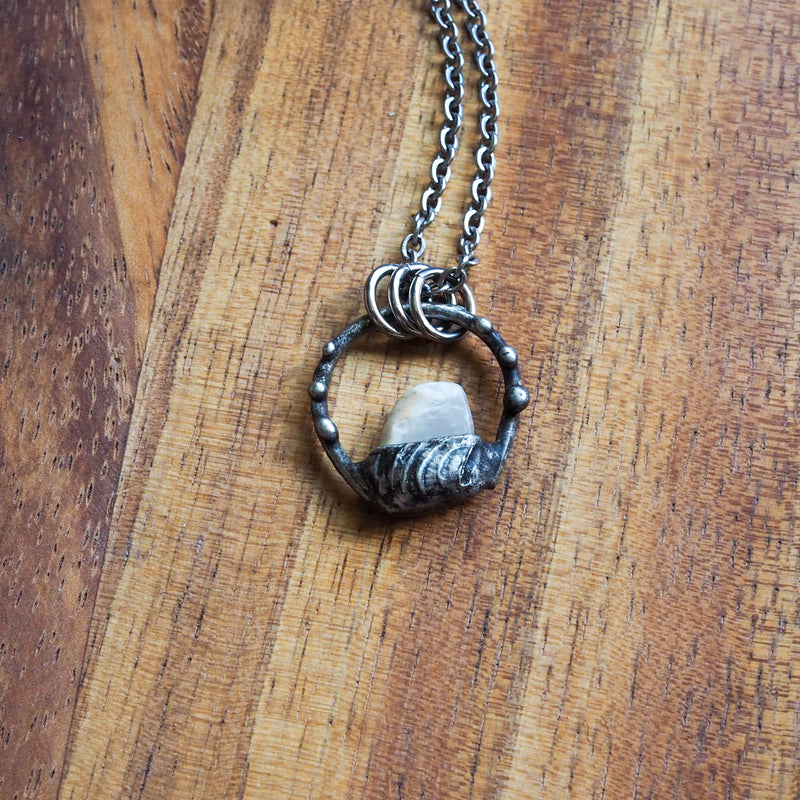 white moonstone healing crystal talisman necklace on wooden background
