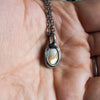 seashell healing crystal talisman necklace in palm of hand