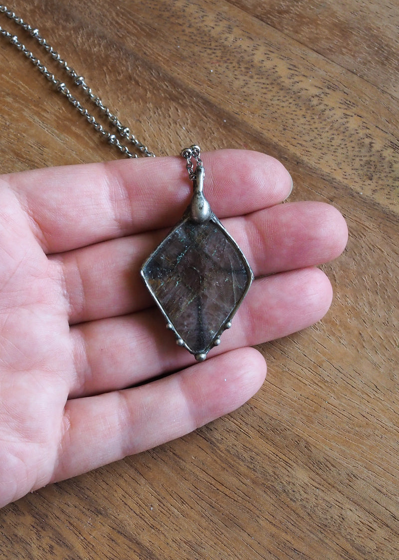 brown crystal talisman necklace in palm of hand