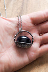 rustic dark blue sparkly crystal talisman necklace in palm of hand