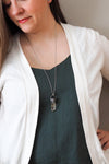 rustic chunky pale yellow crystal point layering talisman necklace on woman in blue top with white cardigan
