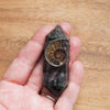 hand holding brown and green healing crystal wand