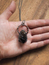 raw smoky quartz healing crystal talisman necklace in palm of hand