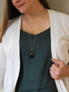 woman in blue top wearing raw smoky quartz healing crystal talisman necklace