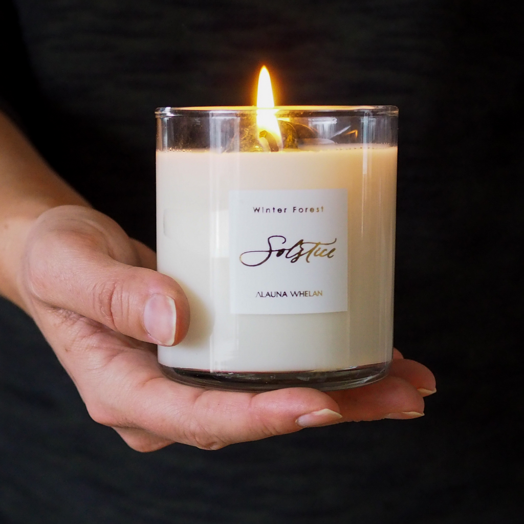 hand holding lit limited edition winter solstice luxury soy crystal candle 